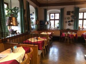 ein Esszimmer mit Tischen und roten Tischdecken in der Unterkunft Gasthaus Klosterhof 