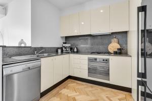 a kitchen with white cabinets and stainless steel appliances at Bev's Retreat by Ready Set Stay in Melbourne