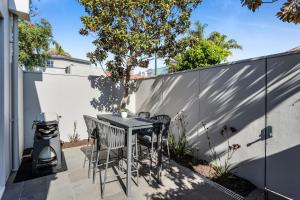 a patio with a table and chairs and a fence at Bev's Retreat by Ready Set Stay in Melbourne