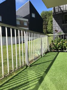 a white picket fence in front of a yard at Le Lodge d Angèle in Honfleur