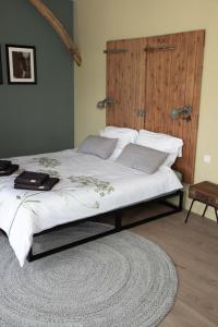 um quarto com uma cama grande e uma cabeceira em madeira em The Cat and The Owl B&B em Groenlo