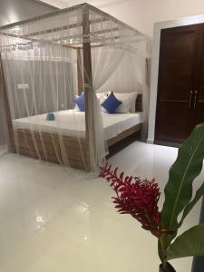 a bedroom with two beds and a vase with a plant at SOHA Home Stay in Galle