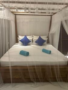 a large bed with blue pillows on top of it at SOHA Home Stay in Galle