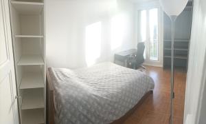 a bedroom with a bed and a desk and a window at Appartement cosy 6 personnes proche gare in Rueil-Malmaison
