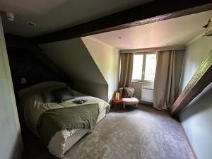 a bedroom with a bed and a window at Ferme Marie Hélène in Ittlenheim
