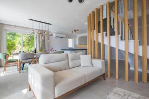 a living room with a couch and a dining room at BEACHFRONT WHITE VILLA WİTH PRIVATE SWIMMING POOL in Kalkan