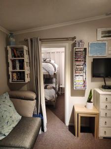 a bedroom with a bed and a tv and a mirror at Beachbach16 - Kakanui in Kakanui