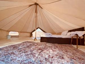 a large tent with a bed in it at Desert Stars Camp in Badīyah