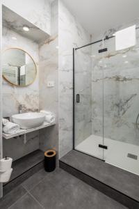 y baño con ducha acristalada y lavamanos. en Area1 Center Luxury Apartment with sauna en Rijeka