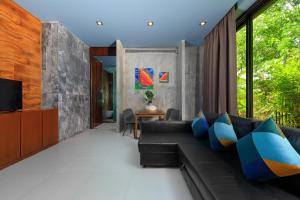 een woonkamer met een bank en een televisie bij Romantic villa in the tropics near Kamala Beach in Kamala Beach