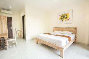 1 dormitorio con 1 cama y 1 silla en Ohana Homestay Canggu, en Canggu