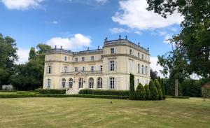 Le Boulay-MorinChâteau du Boulay Morin的前面有草地庭院的大建筑