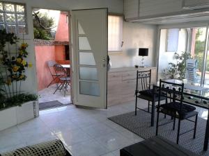 a kitchen with a table and chairs and a door at roxane Appartement F1 Bis Face A La Mer in Collioure