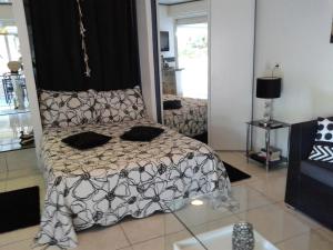 a bedroom with a bed with a black and white comforter at roxane Appartement F1 Bis Face A La Mer in Collioure