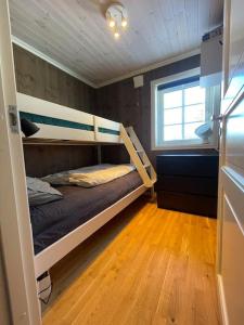 Nordset的住宿－Modern cabin at Budor, close to Hamar and Løten, 1,5 hours from Oslo，一间卧室设有两张双层床,铺有木地板。