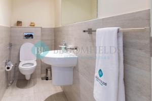 La salle de bains est pourvue de toilettes blanches et d'un lavabo. dans l'établissement Stylish 1 Bedroom In Oasis, à Al Qurayyah