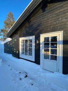Una casa con dos puertas a un lado. en Modern cabin at Budor, close to Hamar and Løten, 1,5 hours from Oslo, en Nordset