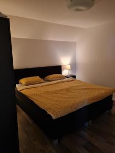 um quarto com uma cama grande e um edredão castanho em T Karraet em Maasmechelen