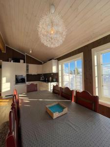 Nordset的住宿－Modern cabin at Budor, close to Hamar and Løten, 1,5 hours from Oslo，一间带桌子和吊灯的用餐室