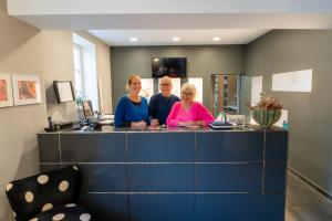 a group of three people standing at a counter at Hotel Bergbauer mit Late-Self-Check-IN in Neuburg an der Donau