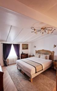 Hotel Dandy Rouen centre في رووين: غرفة نوم بسرير كبير مع ستائر ارجوانية