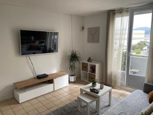 uma sala de estar com uma televisão de ecrã plano na parede em superbe duplex avec parking gratuit em Grenoble