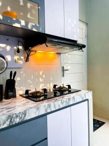 a kitchen with a stove and a counter top at Homestay Kamar Tamu Sedayu in Bantul