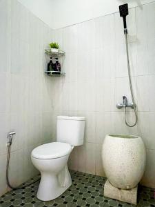 y baño con aseo y ducha. en Homestay Kamar Tamu Sedayu en Bantul