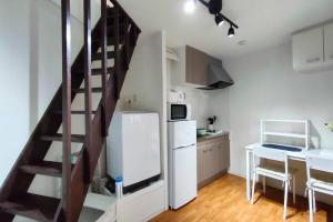 a kitchen with a staircase and a refrigerator and a table at Osaka 1min walk-Sta. 6min to Namba 3ppl House USJ times in Osaka