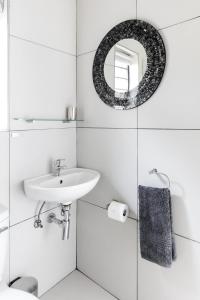 Baño blanco con lavabo y espejo en Bona Vista Self-Catering Accommodation en Klapmuts