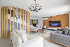 a living room with white furniture and a tv at BEACHFRONT WHITE VILLA WİTH PRIVATE SWIMMING POOL in Kalkan