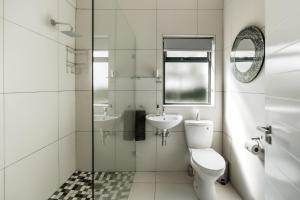 a white bathroom with a toilet and a sink at Bona Vista Self-Catering Accommodation in Klapmuts