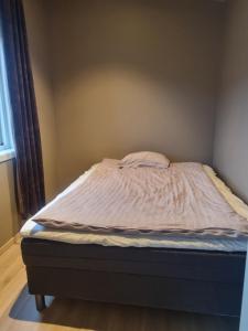 uma cama não feita num quarto com uma janela em Apartment mandal 