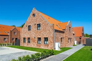 um edifício de tijolos com telhado laranja em FriesenKOJE 1 mit Garten,Hund willkommen! em Greetsiel