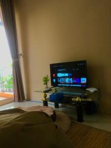 Una sala de estar con un televisor de pantalla plana sobre una mesa. en Villa Sentul Onnelik Sentul City Bogor by Villaloka, en Babakan Madang