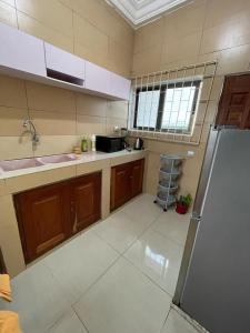 a kitchen with a sink and a refrigerator in it at WAZAN in Cotonou