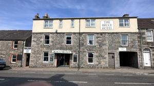 a building with two men sitting on top of it at The Bruce Hotel in Newton Stewart