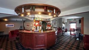 a bar in a pub with a bar counter at The Bruce Hotel in Newton Stewart