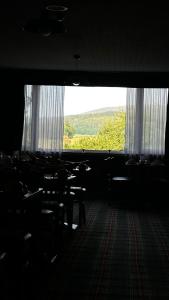 Cette chambre dispose de tables, de chaises et d'une grande fenêtre. dans l'établissement The Bruce Hotel, à Newton Stewart