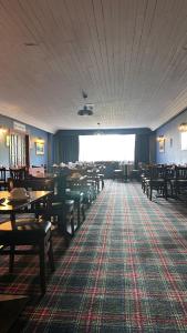 a dining room with tables and chairs and a rug at The Bruce Hotel in Newton Stewart