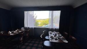 The Bruce Hotel في نيوتن ستيوارت: غرفة طعام مع طاولتين ونافذة