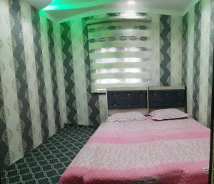 Chimgan的住宿－Дом у подножия гор，一间卧室配有一张带粉色床单的床和一扇窗户。