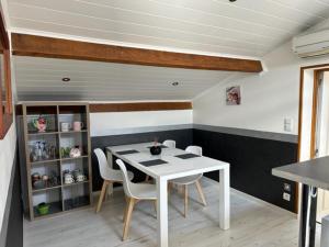 comedor con mesa blanca y sillas en Appartement mansardé et climatisé 50 m2, en Pompignan