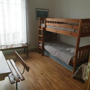 Cette chambre comprend 2 lits superposés et une table. dans l'établissement Brest quartier Siam appartement 3 étoiles, à Brest