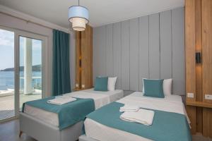 two beds in a room with a view of the ocean at BEACHFRONT WHITE VILLA WİTH PRIVATE SWIMMING POOL in Kalkan +55 photos