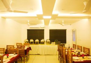 a dining room with tables and chairs and a table with glasses at Palette Hill View Resorts Vagamon in Vagamon