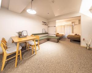 a room with a table and chairs and a bedroom at Apartment Hotel 11 Shinsaibashi in Osaka
