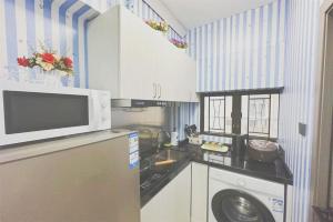 a kitchen with a washing machine and a microwave at apt 4BR10pax, 2bar ,1mins mtr in Hong Kong