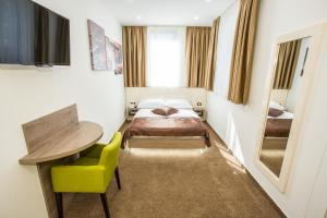 a bedroom with a bed and a table and a chair at Hotel National in Zagreb