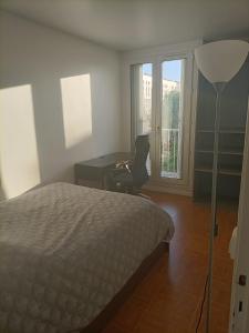 a bedroom with a bed and a desk and window at Appartement cosy 6 personnes proche gare in Rueil-Malmaison